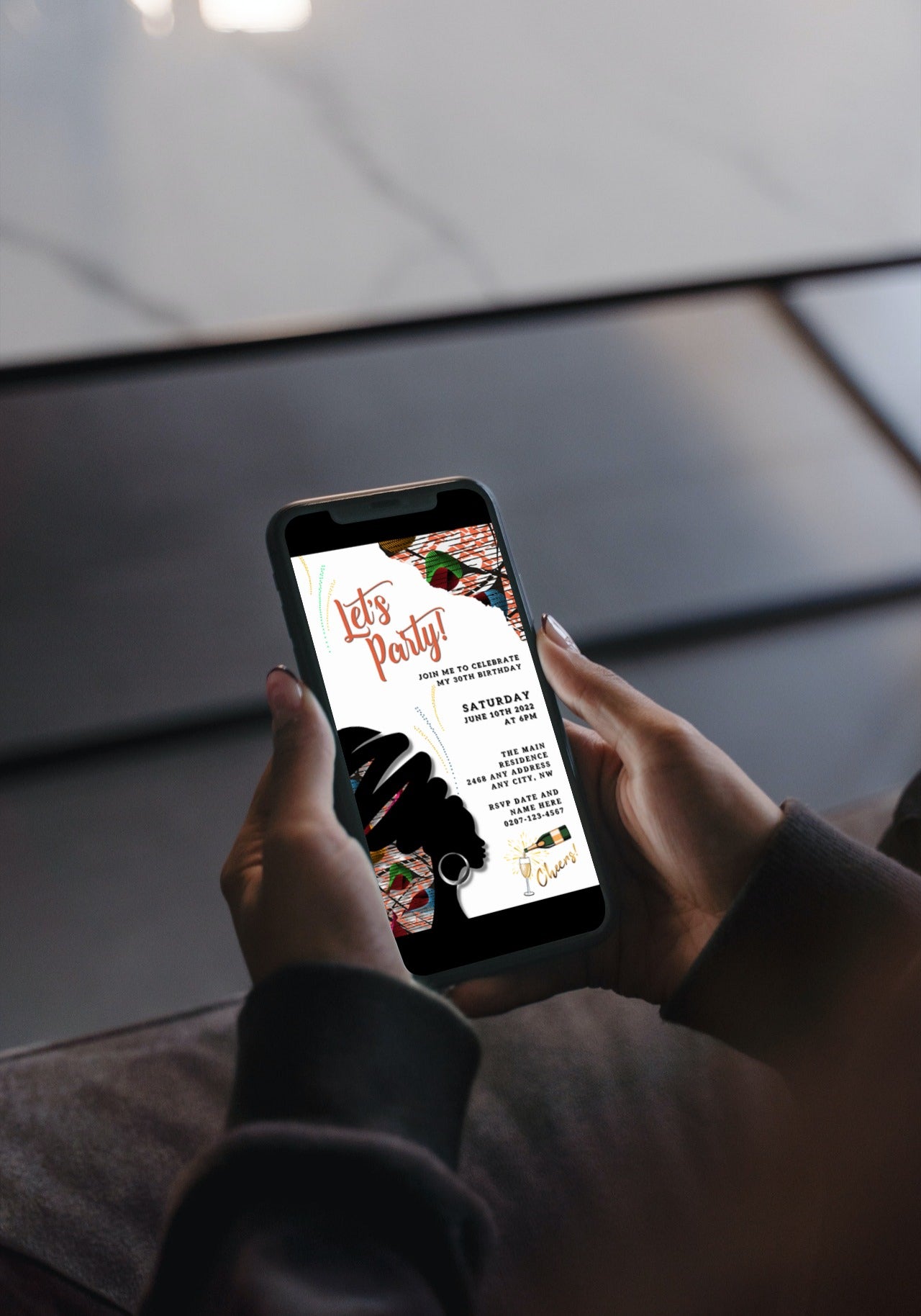 Person holding a phone displaying the White Beige Ankara African Woman Silhouette Editable Party Evite template, ready for customization and digital sharing.