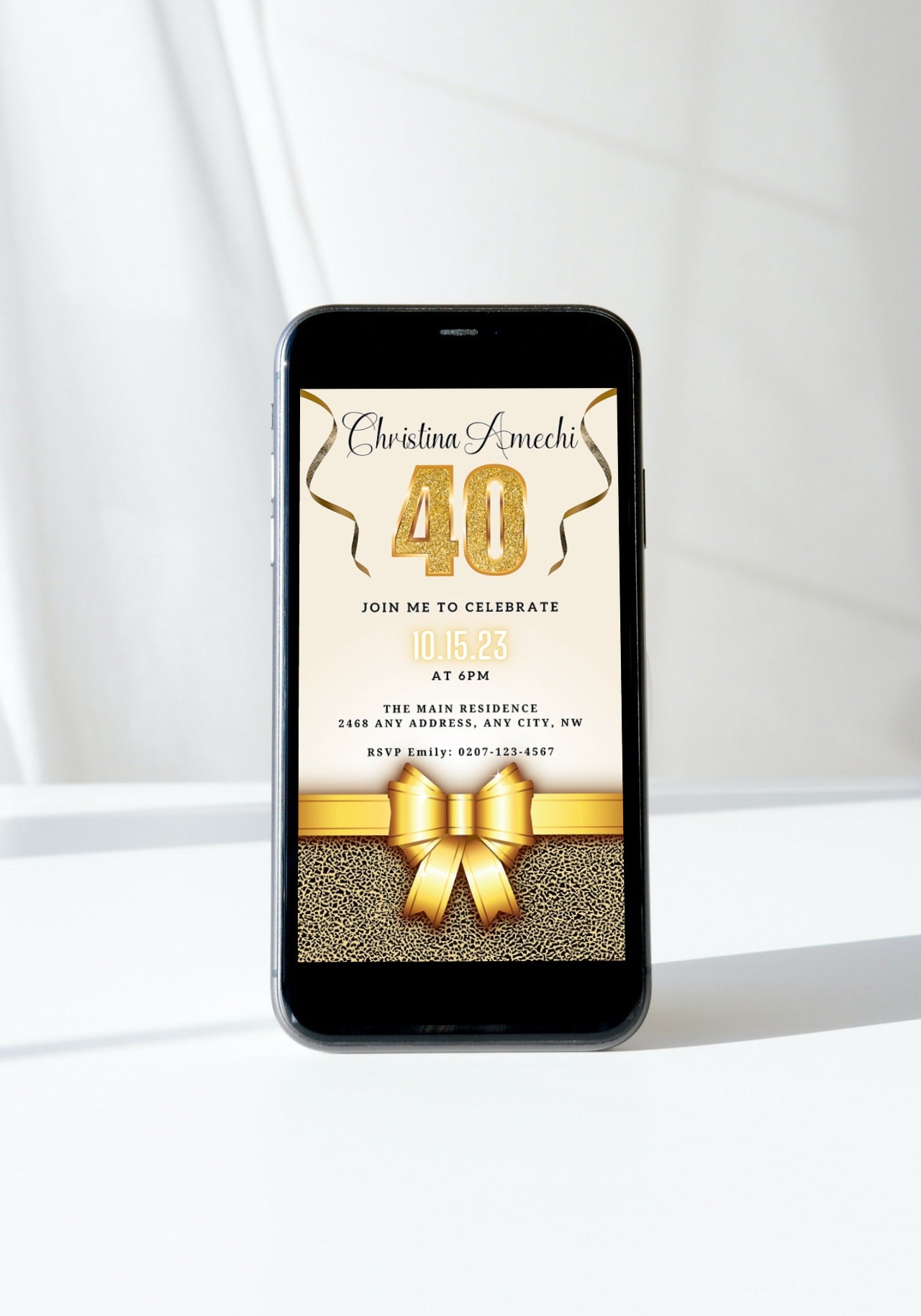 Cell phone with a gold ribbon and bow, showcasing the Beige Gold Leopard 40th Birthday Evite from URCordiallyInvited.