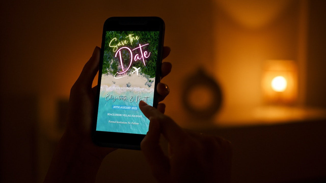 A person holding a smartphone displaying a customizable Exotic Beach Destination | Save The Date Video Invitation template.