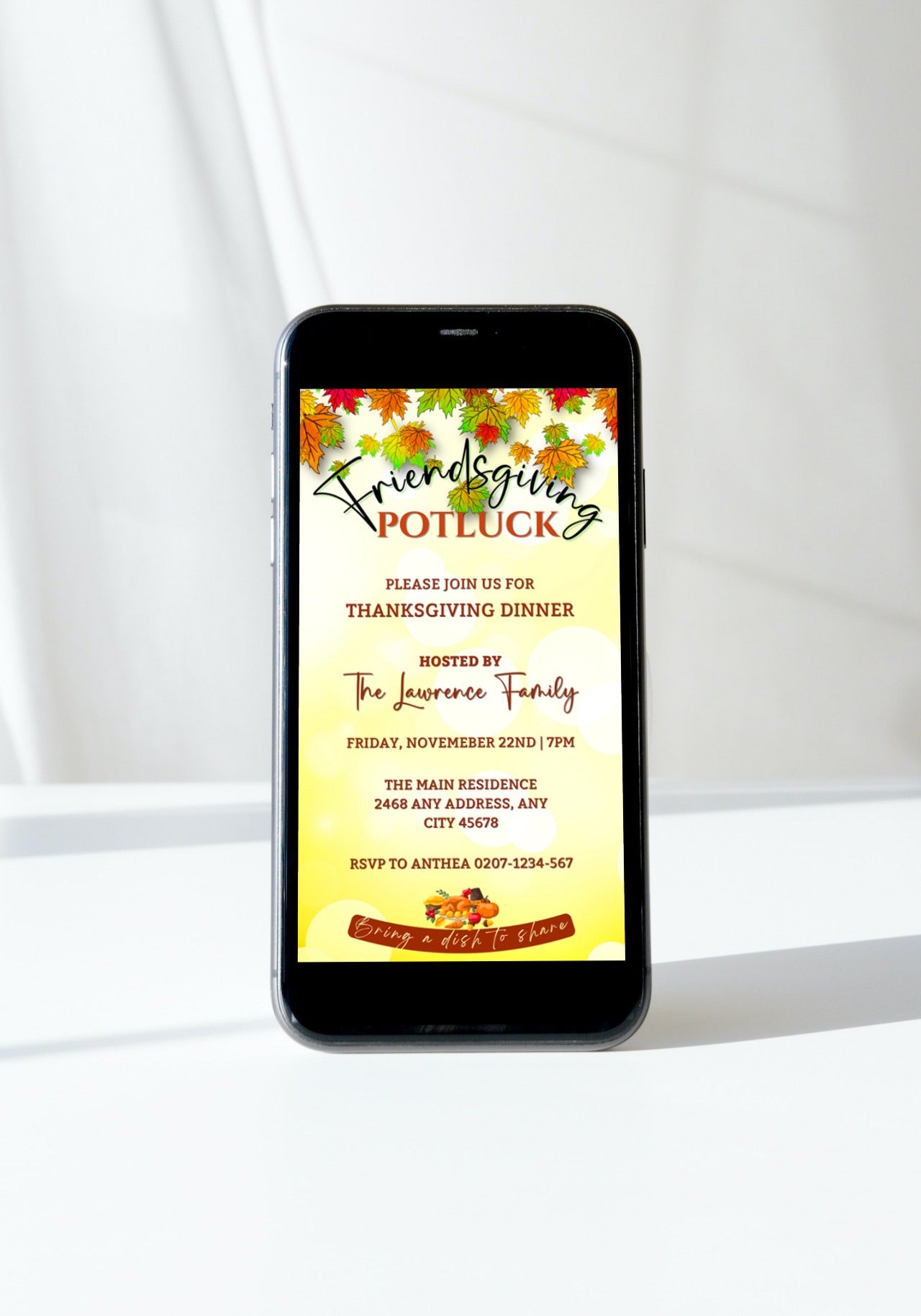 Cell phone displaying Friendsgiving Potluck Autumn Leaves Thanksgiving Dinner Evite, with a close-up of food and various text elements.