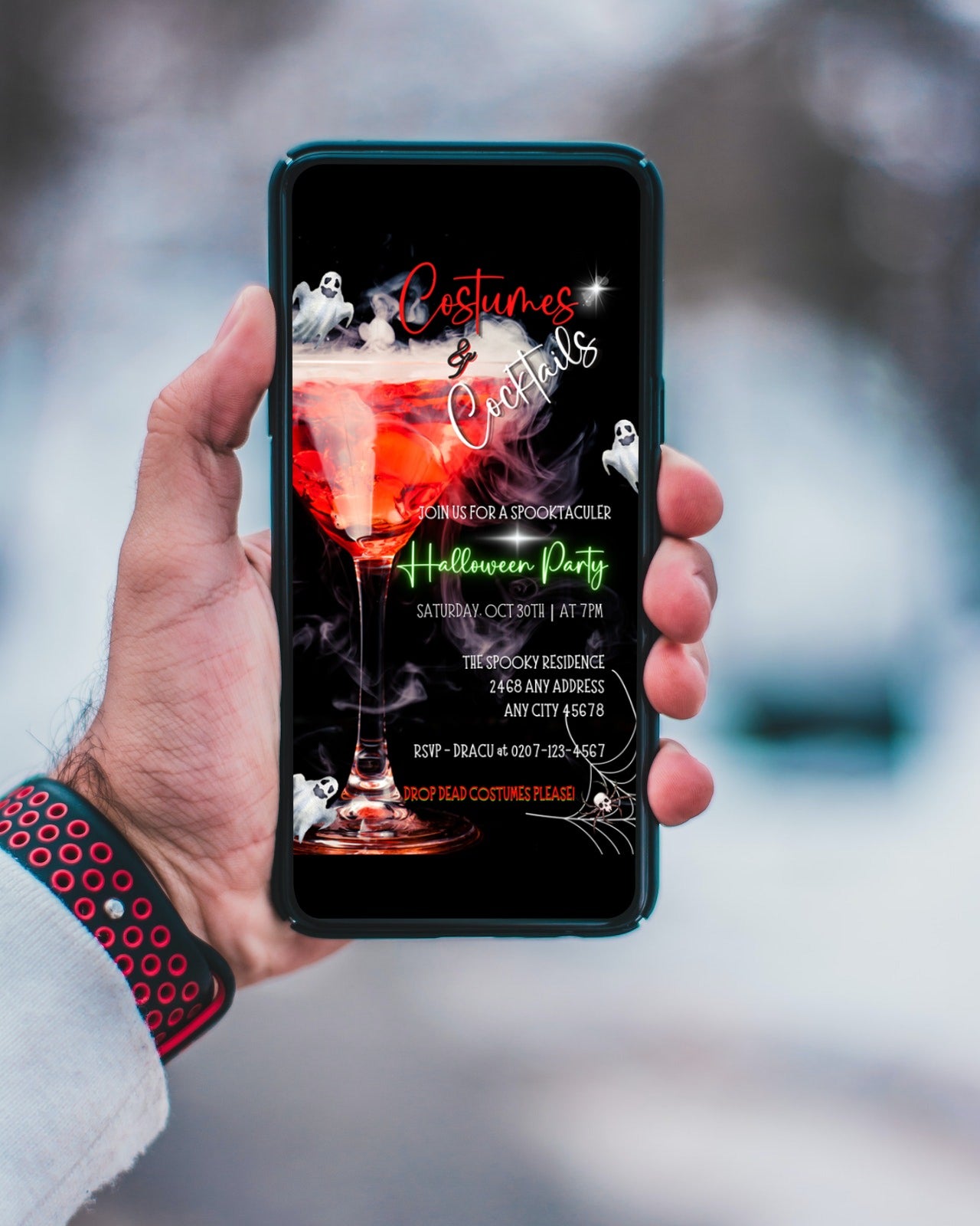 Hand holding a cell phone displaying Smoking Wine Glass Ghosts Costumes & Cocktails Halloween Evite template for customisation in Canva, URCordiallyInvited eco-friendly digital invitation.