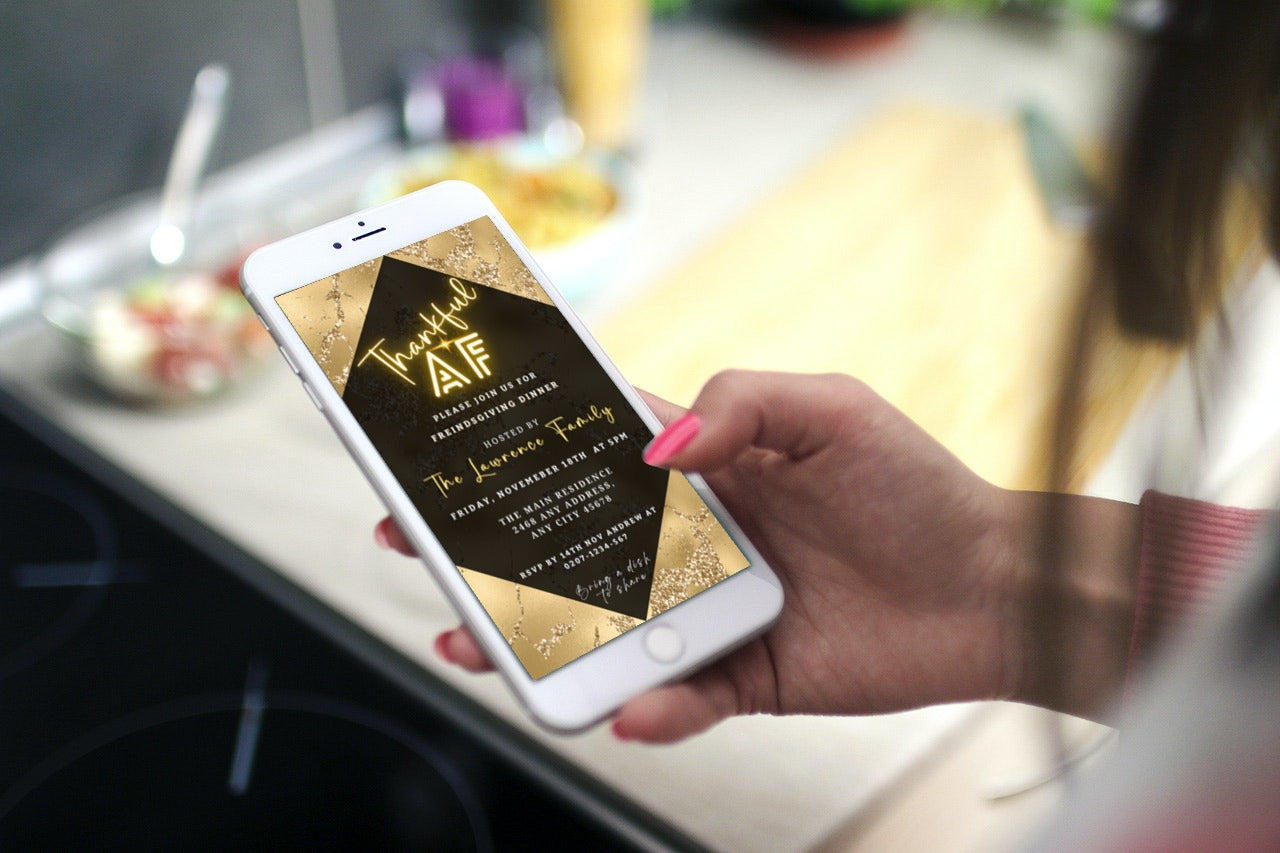 Hand holding a phone displaying Golden Neon Glitter | Thankful AF Thanksgiving Evite template, editable via Canva for personalized digital invitations.