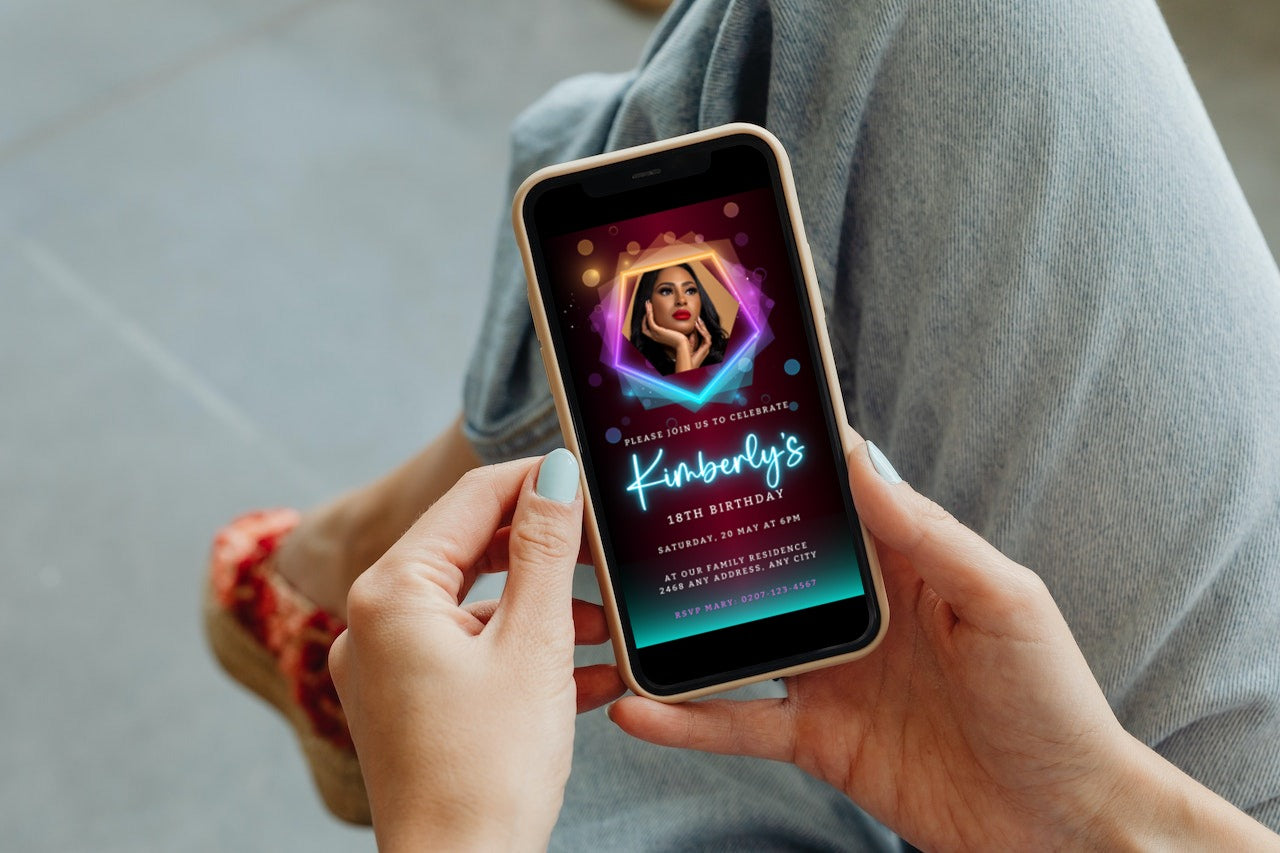 Person holding a phone displaying a customizable digital Birthday Party Evite template, Neon Maroon Teal with Photo, for editing and sharing via smartphone.