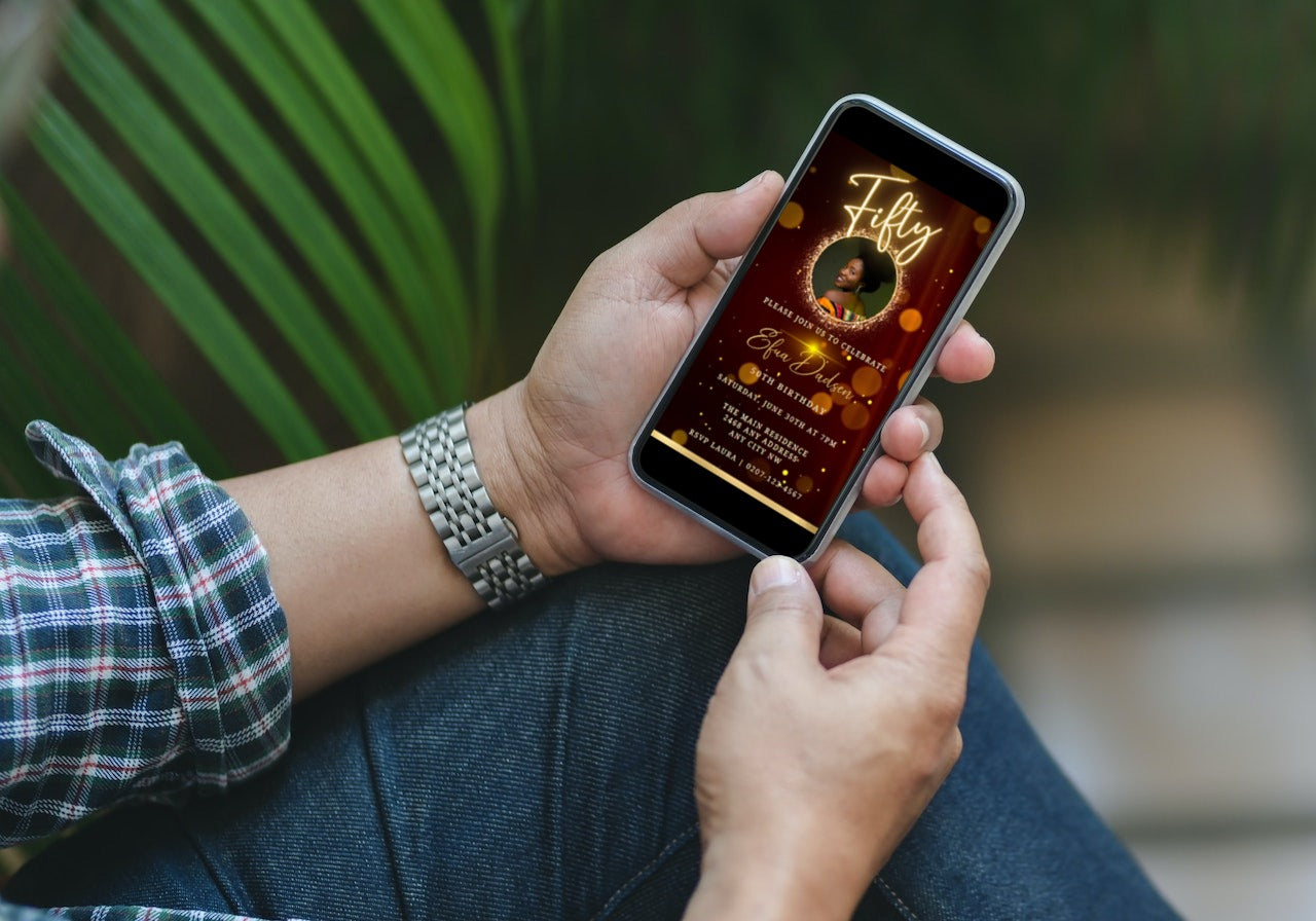 Person holding a smartphone displaying a 50th Birthday Video Invitation template with editable details for customization in Canva.