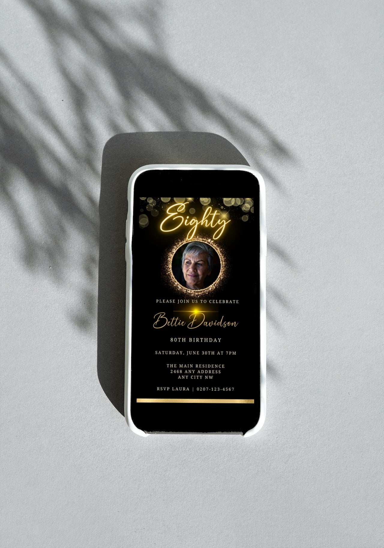 Customisable Gold Neon 80th Birthday Evite displayed on a smartphone, featuring a photo of a woman within an oval frame and editable text.