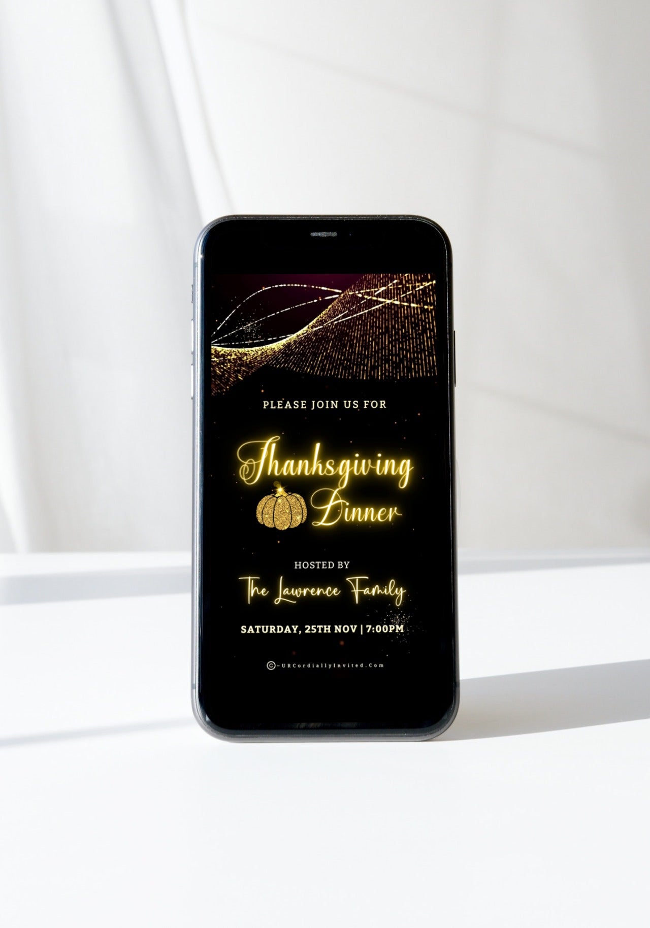 Gold Pumpkin Motion Glitter | Thanksgiving Dinner Video Invite displayed on a cell phone screen, featuring a black background and gold text with a pumpkin decoration.