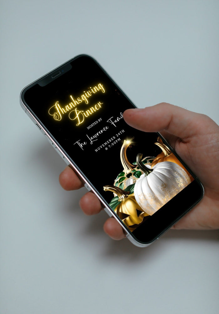 Hand holding a cell phone displaying the Jewel Glitter Pumpkins Thanksgiving Dinner Video Invite template for customization.