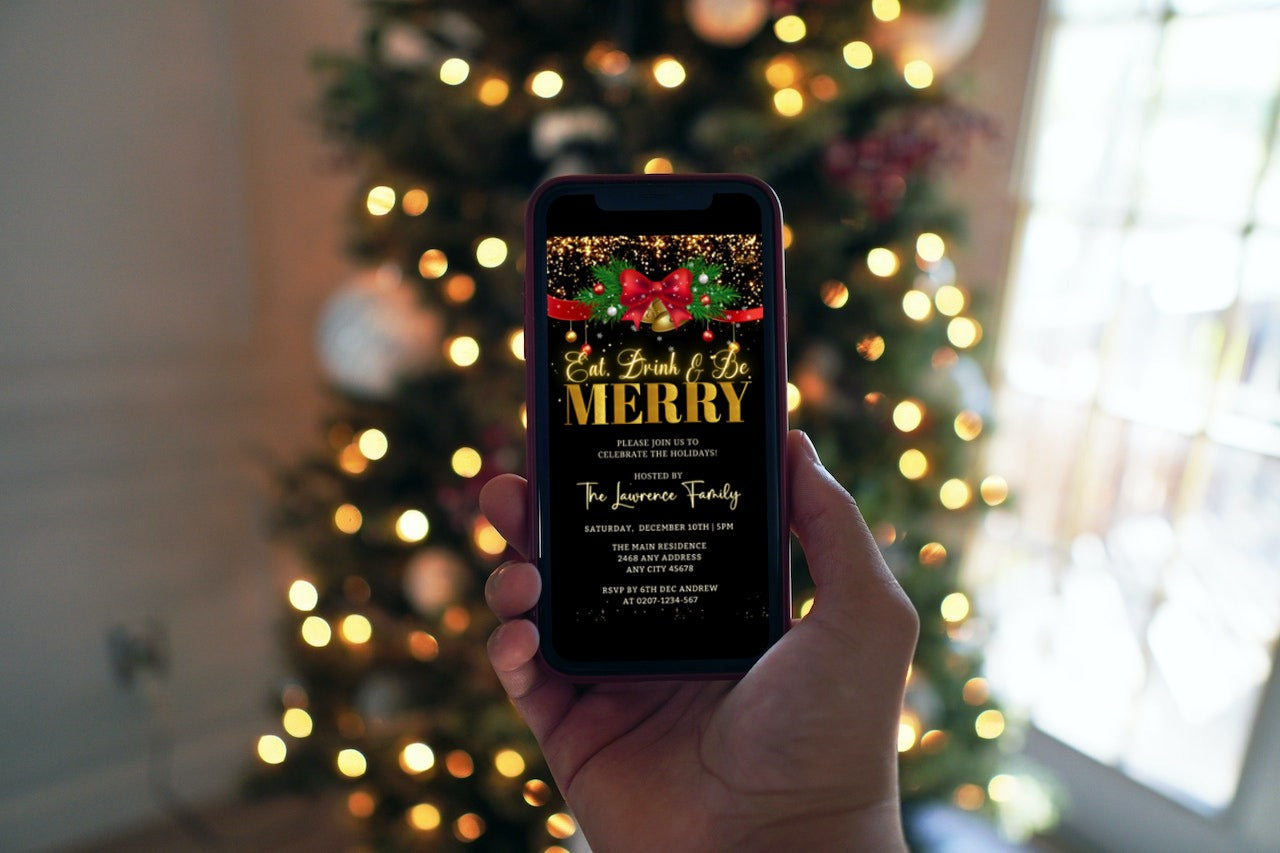 Hand holding a phone displaying a customizable Red Bell Bow Merry Glitter Christmas Party Video Invite with a Christmas tree in the background.