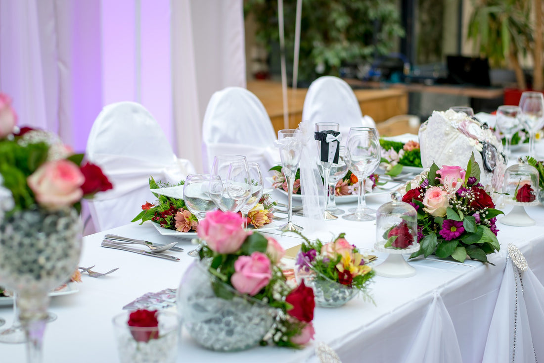 Elegant wedding reception table setting with white floral centerpieces