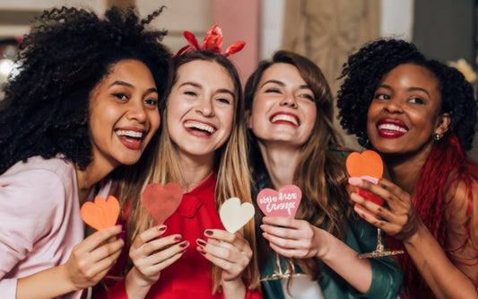 A diverse group of beautiful young ladies smiling at a galantines party