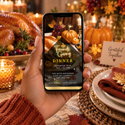 Hand holding phone displaying a turkey-themed Friendsgiving video invite; festive table setting in background.