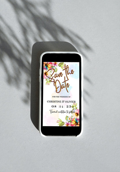 Smartphone displaying a customizable Save The Date video invitation with floral white greenery design, editable via Canva for personal events.