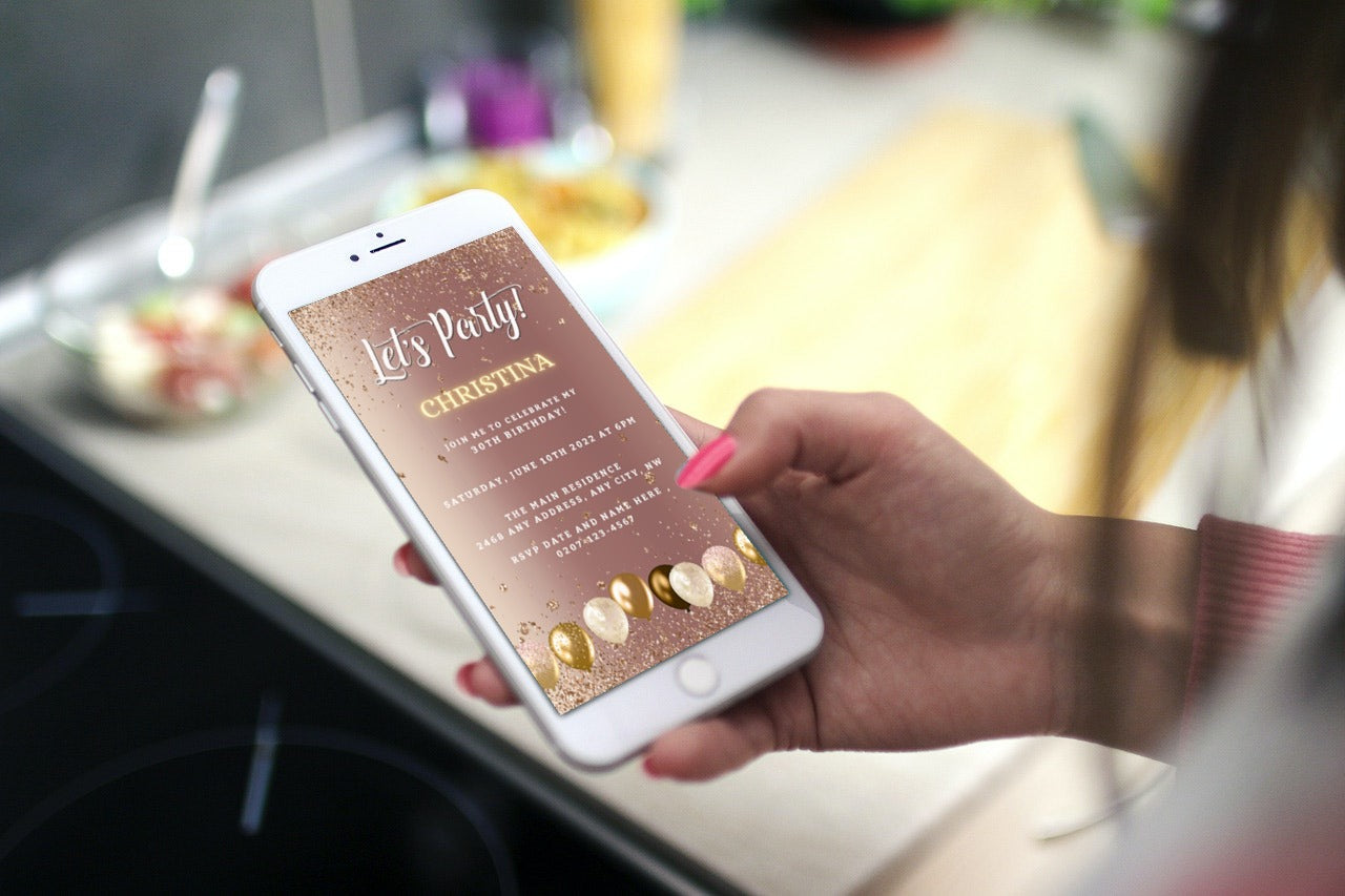 Hand holding a smartphone displaying an editable Rose Gold Balloons Birthday Evite from URCordiallyInvited, customizable via Canva for digital sharing.