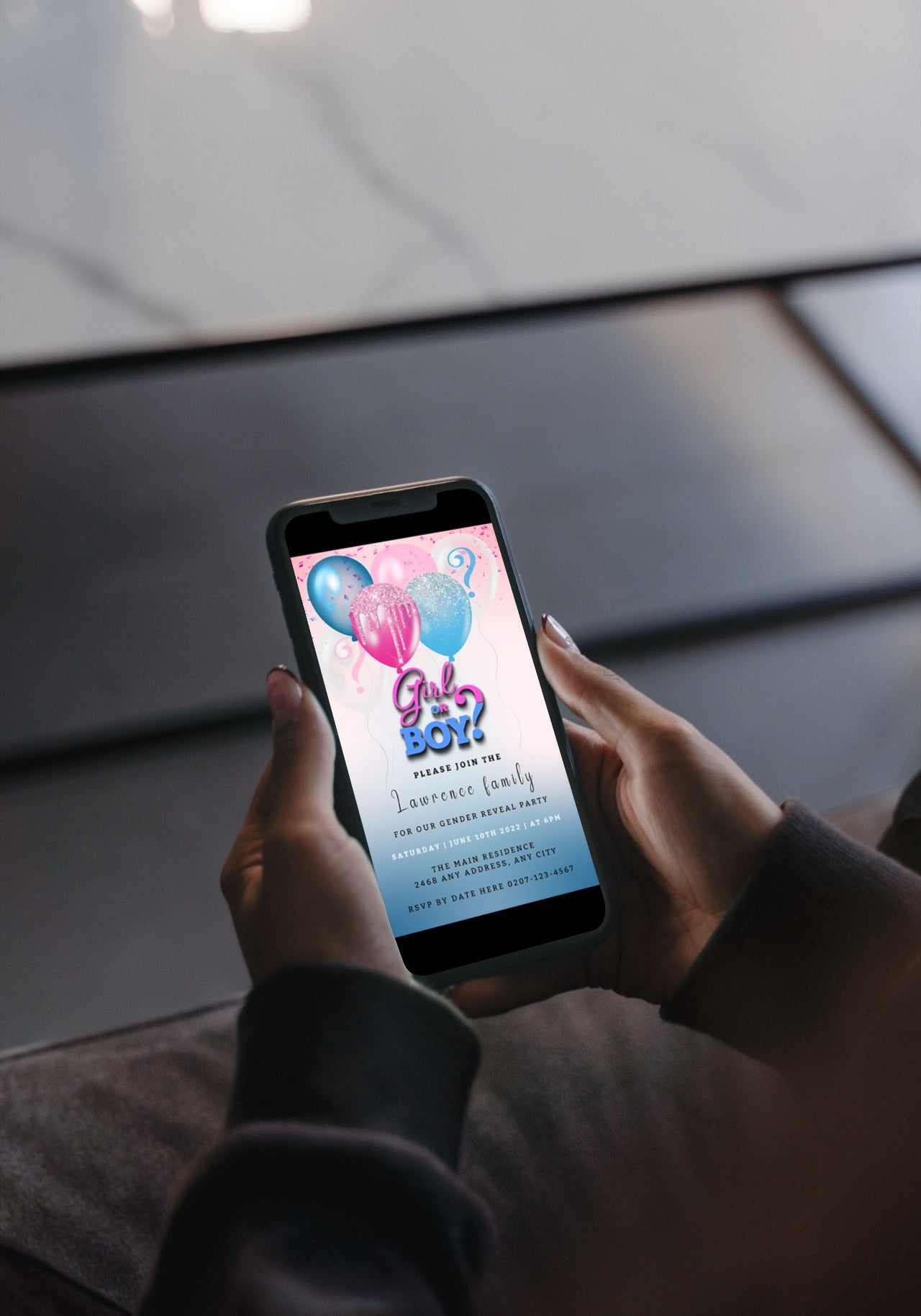 Person holding a phone displaying a customisable Gender Reveal Party Evite with pink and blue floating balloons, editable via Canva for easy sharing.