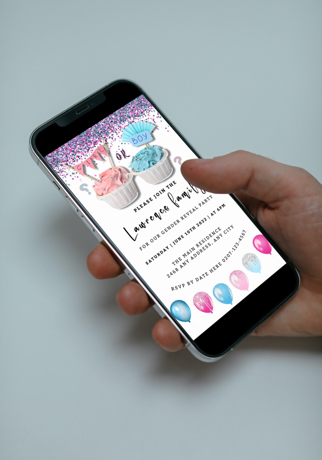 Hand holding a smartphone displaying the customizable Cupcake Blue Pink Confetti | Gender Reveal Evite digital invitation template.