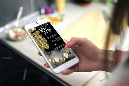 A hand holding a smartphone displaying a Gold Glitter African Woman Silhouette Editable Party Evite.