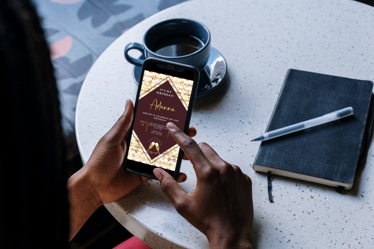 Person holding a smartphone displaying the Beige White African Ankara Editable Party Evite template, ready for customization using the Canva app.