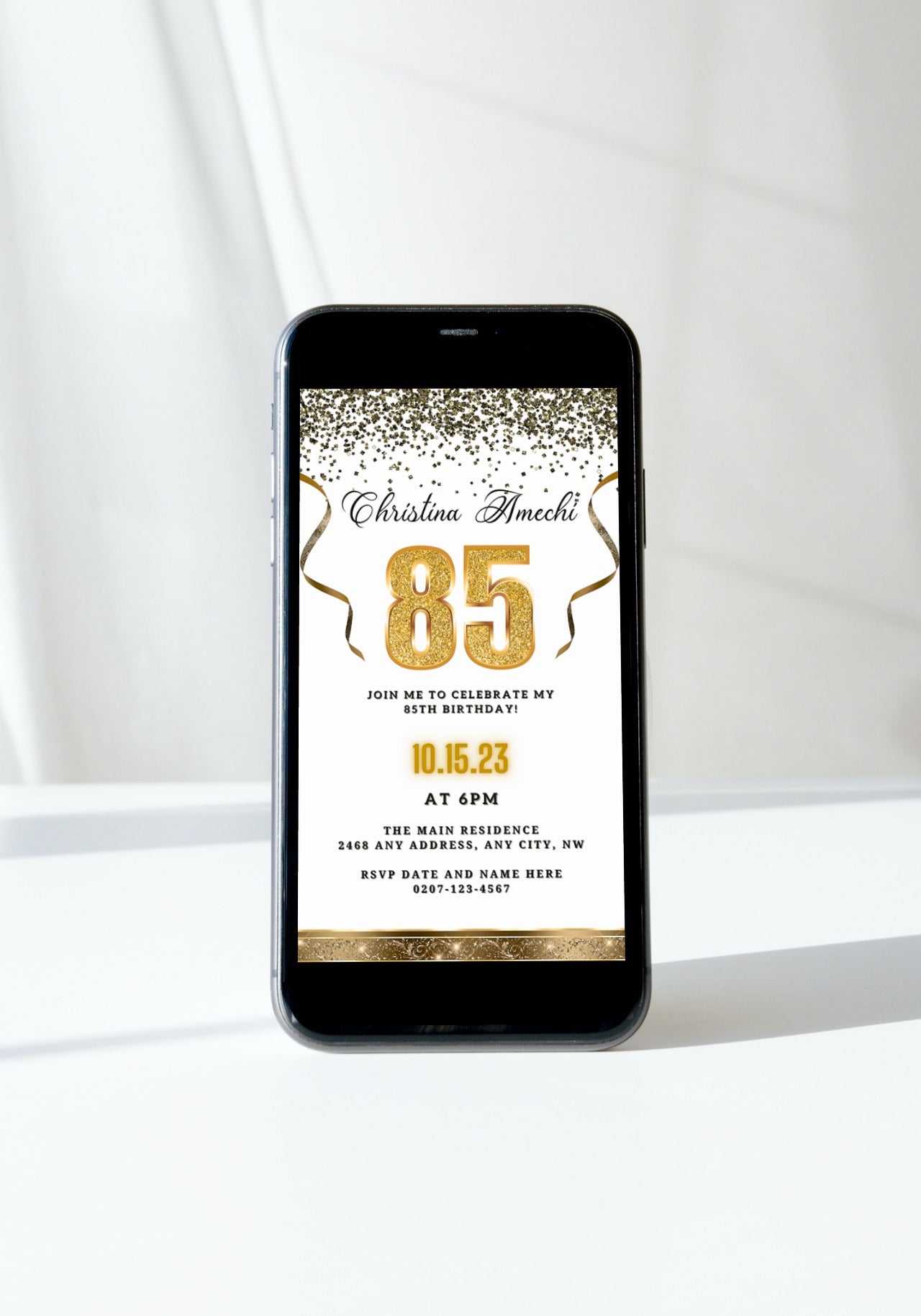 Customizable Digital White Gold Confetti 85th Birthday Evite displayed on a smartphone, featuring editable gold and white invitation elements for personalizing via Canva.