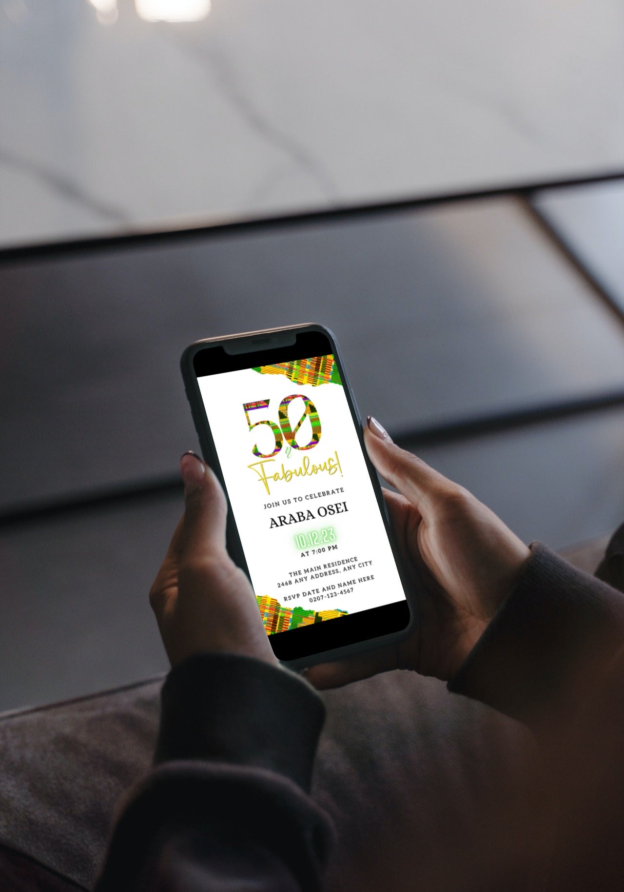 Person holding phone displaying customizable Green Yellow Kente White | 50 & Fabulous Birthday Evite template from URCordiallyInvited.