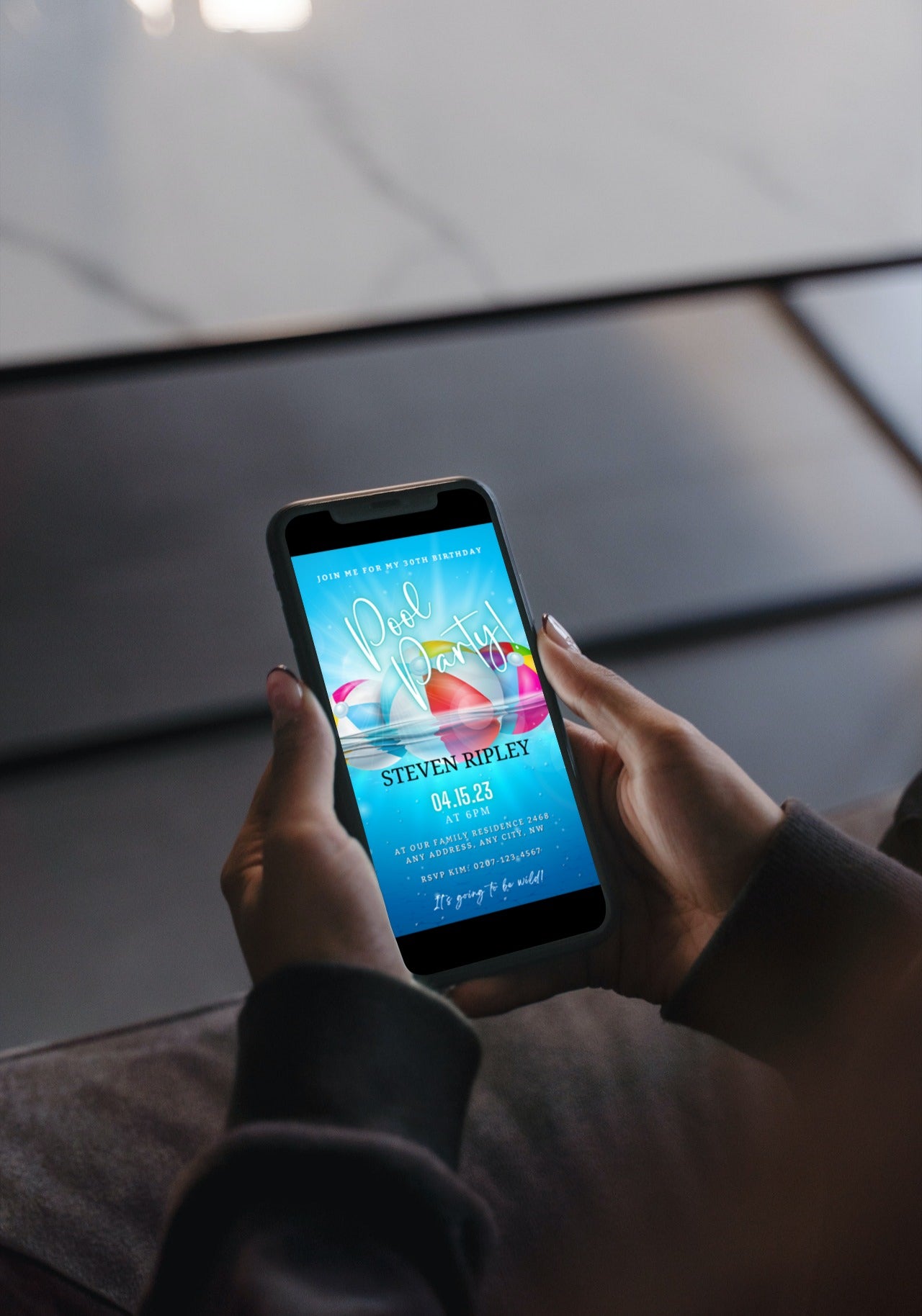 Person holding a smartphone displaying a customizable Digital Aqua Pool Party Invitation template from URCordiallyInvited.