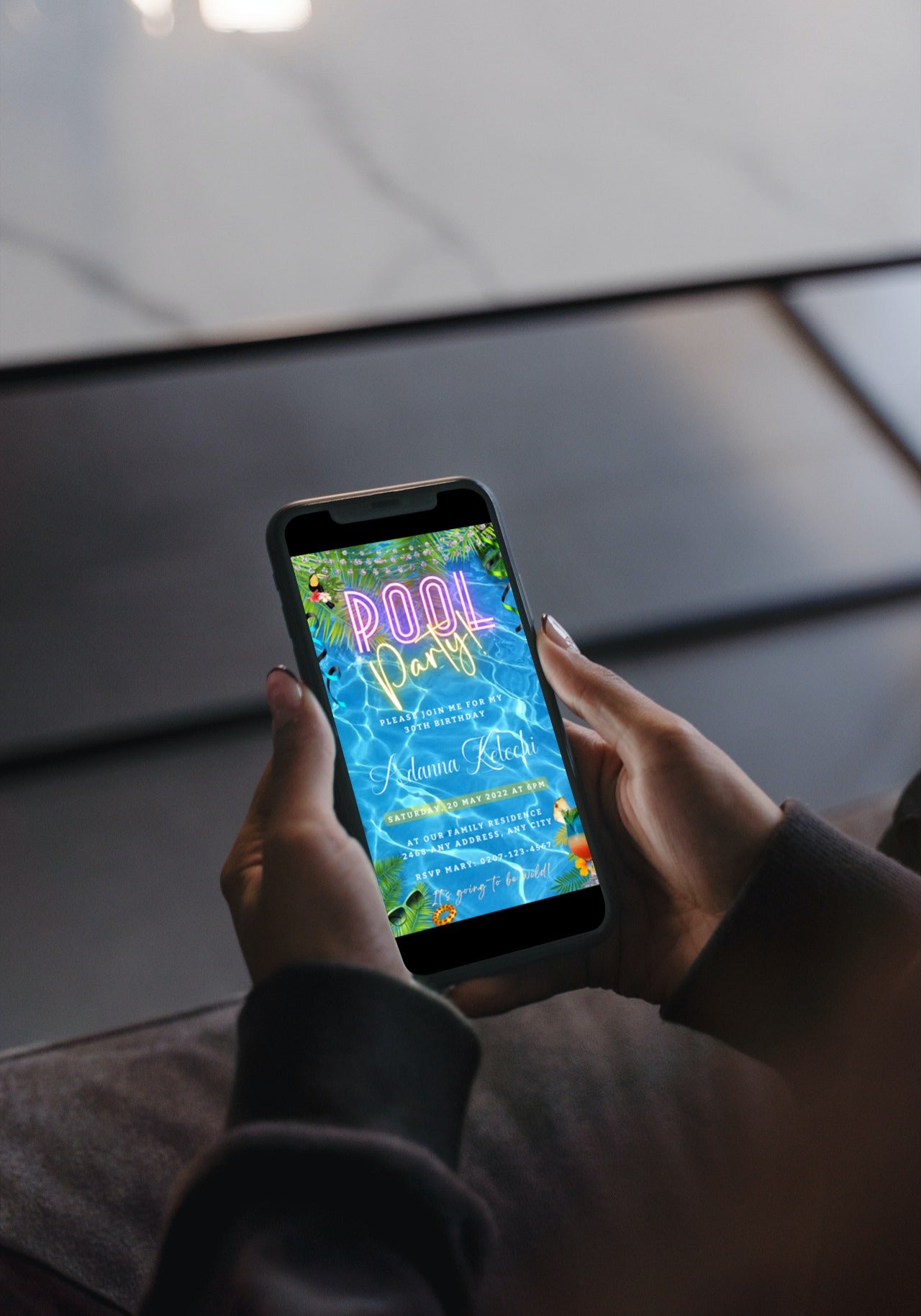 Person holding a smartphone displaying a customizable Birthday Pool Party digital invite template from URCordiallyInvited.