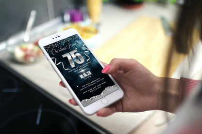 Hand holding a smartphone displaying a customizable Navy Blue Silver Glitter 75th Birthday Evite, ready to personalize and send electronically via various messaging apps.