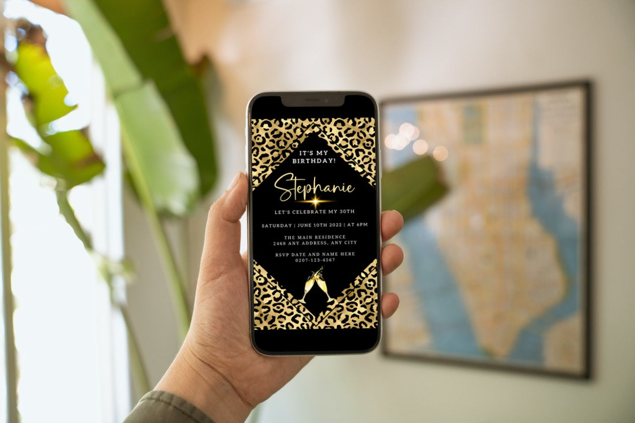 Hand holding a smartphone displaying a customizable Gold Black Leopard Animal Print Party Evite template from URCordiallyInvited.