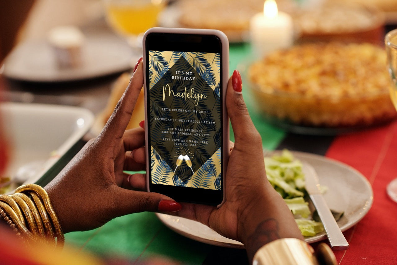 Person holding a phone displaying the Gold Blue Tropical Leaf Birthday Party Evite, an editable digital invitation template for smartphones.