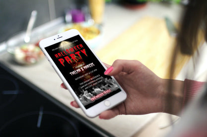 Hand holding a phone displaying the Red Smoking Skull Halloween Party Video Invite, showcasing a red skull hologram with white smoke, customizable via Canva.