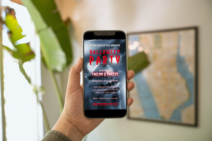 Hand holding a mobile phone displaying the Spooky Lava Ghost Skull | Halloween Party Video Invite template, which is customizable using the Canva design app.