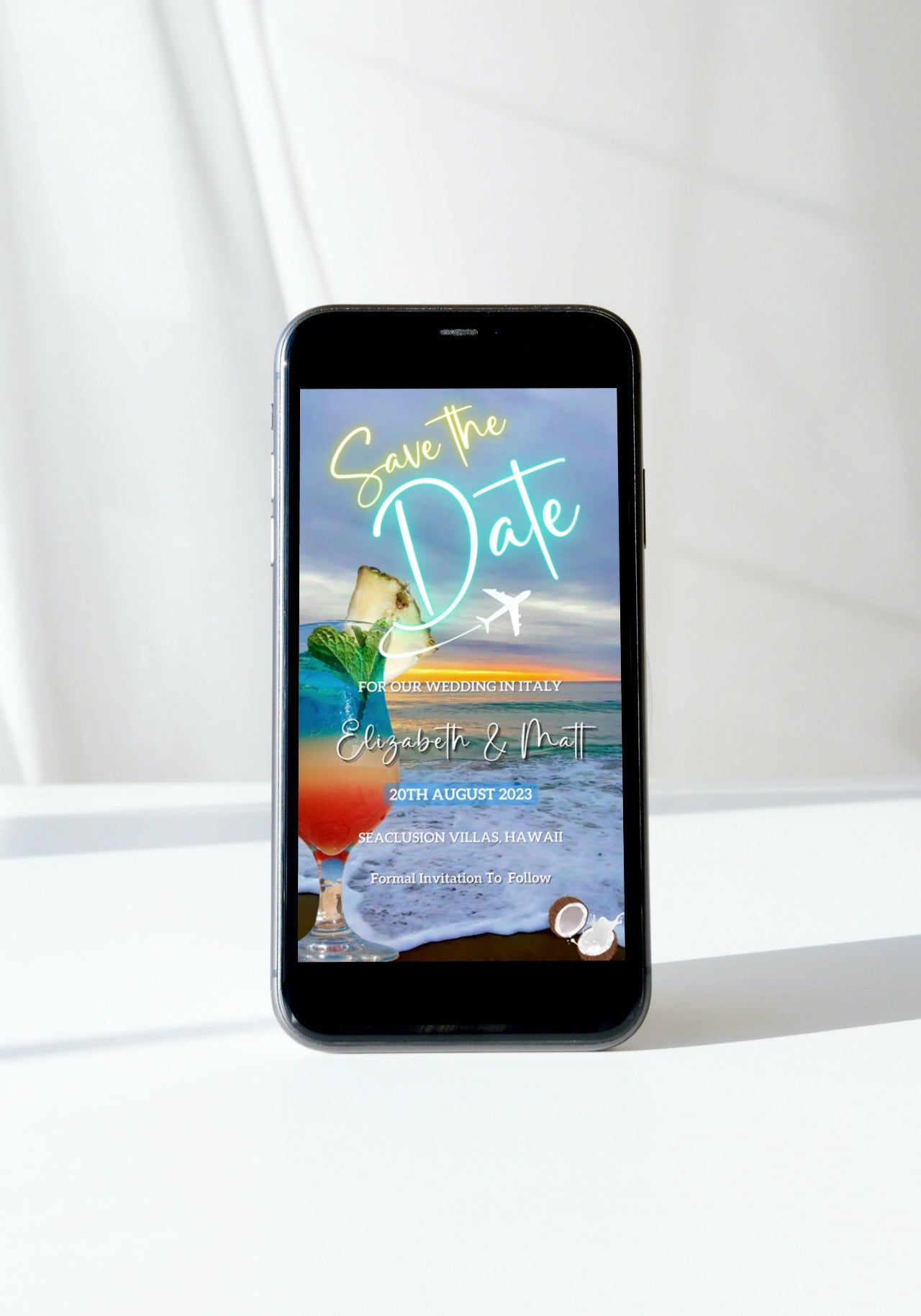 Smartphone displaying Sunset Beach Cocktail Destination | Save The Date Video Invitation, featuring a beach scene with a cocktail, customizable via Canva for digital sharing.