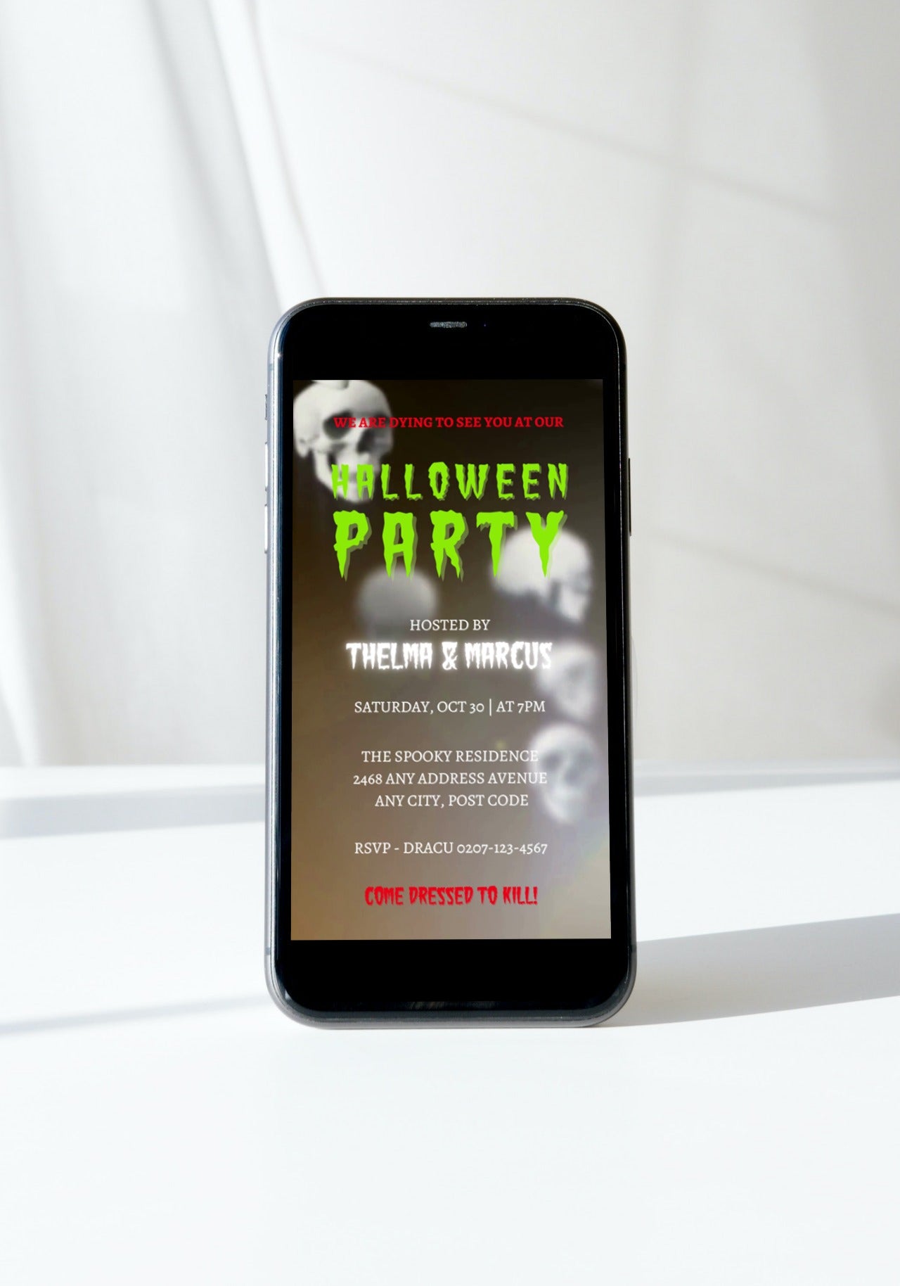 Cell phone displaying a Spinning Smoking Skulls Halloween Party Video Invite with editable text and spooky soundtrack.