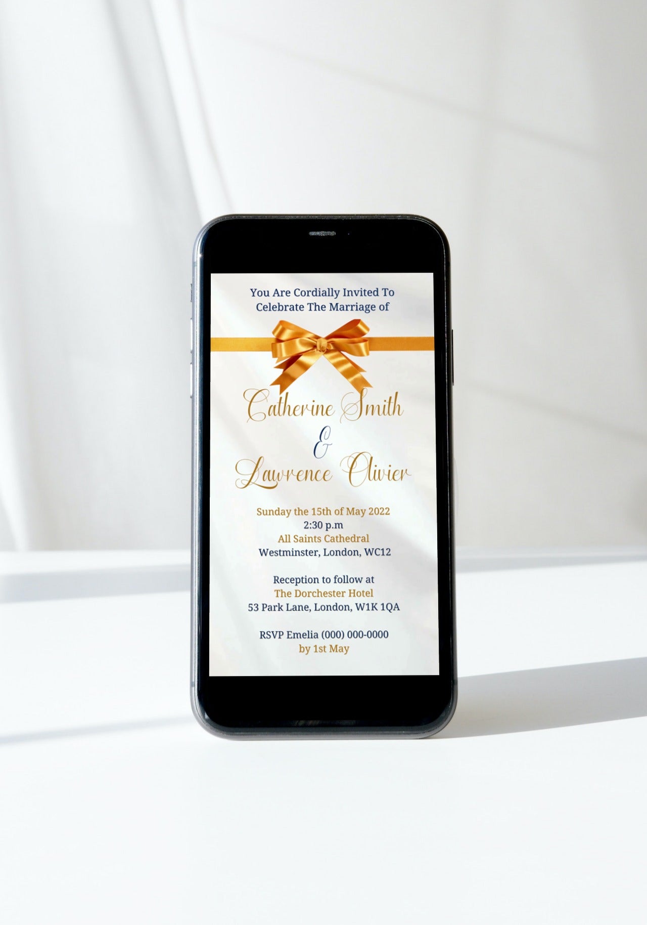 Cell phone displaying customisable Gold White Silk Bow Wedding Video Invitation with a gold bow on the screen.