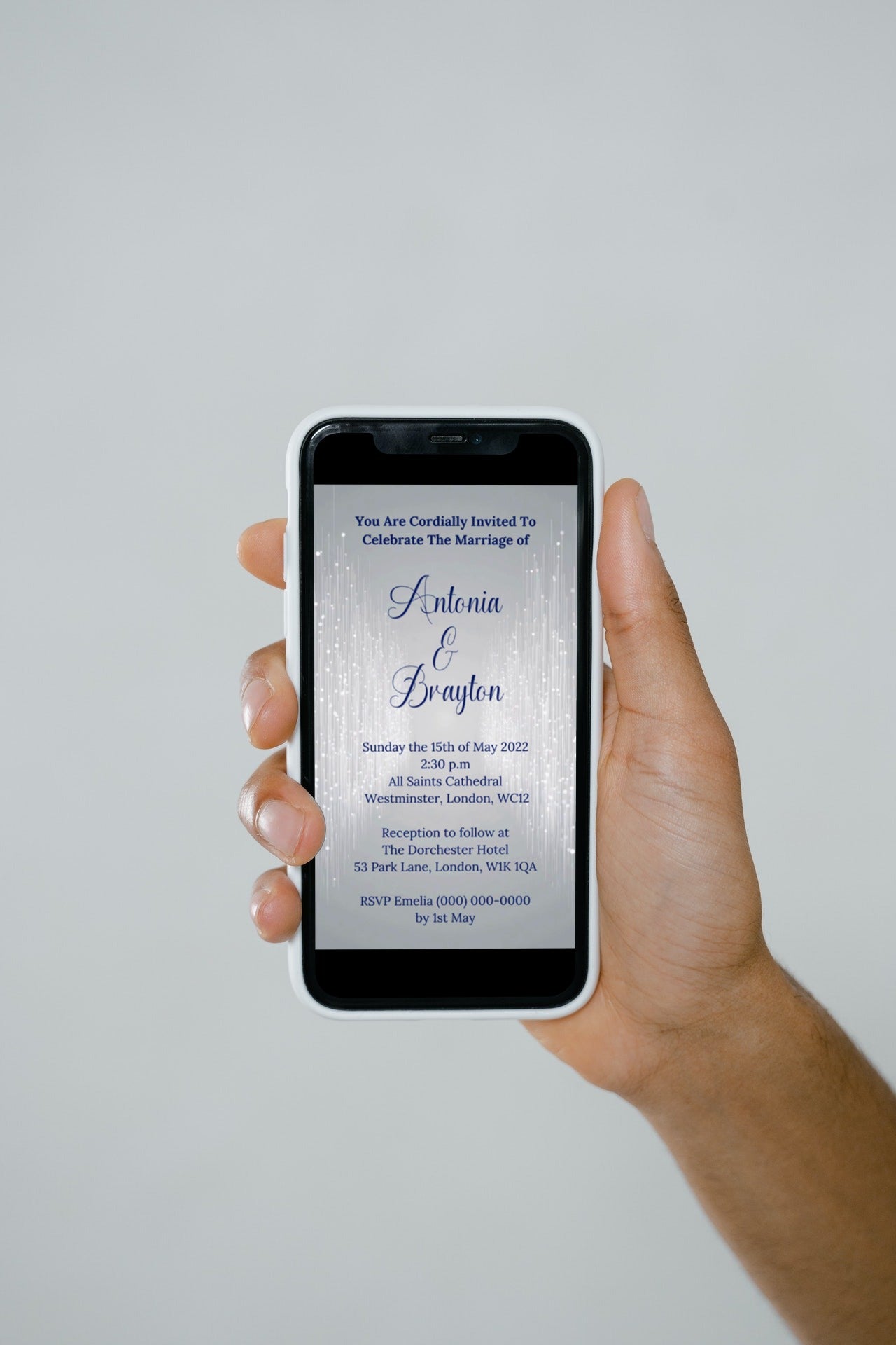 Hand holding a phone displaying a customizable Silver Blue Glitter Wedding Video Invitation template. Ideal for personalizing and sharing digitally via various messaging apps.