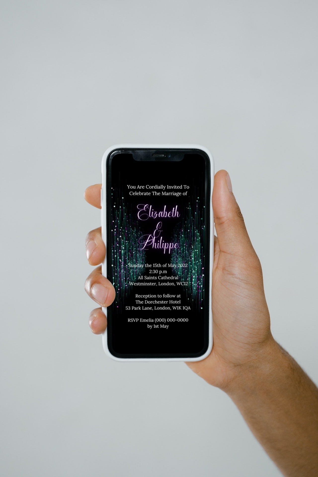 A hand holding a smartphone displays a customizable Green Purple Glitter Wedding Video Invitation template.