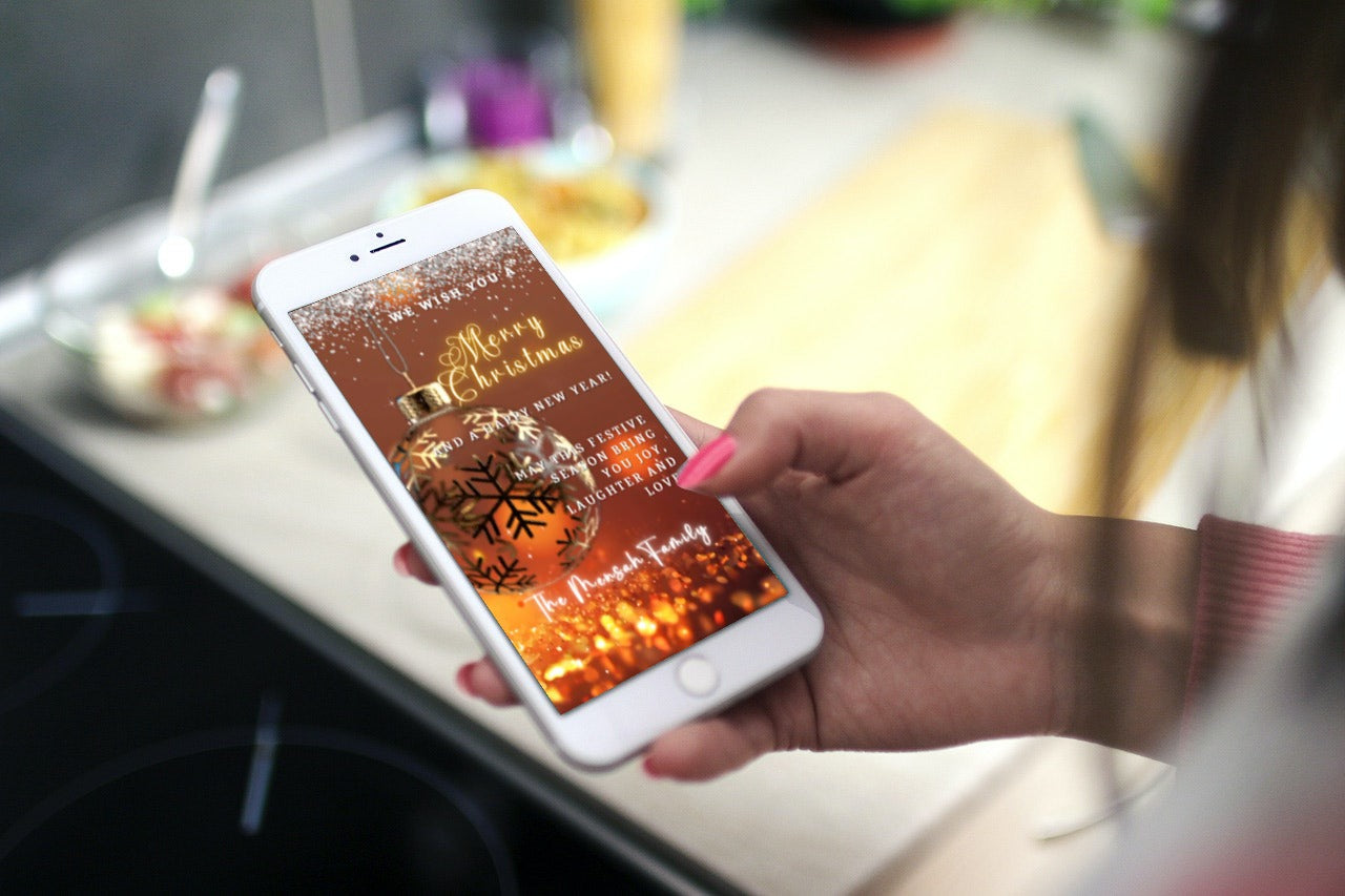 Hand holding a phone displaying the Gold Ball Glitter Christmas Video Ecard, customizable in Canva for easy personalization and sharing via smartphone.