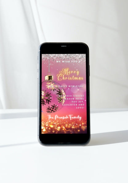 Smartphone displaying the Fuchsia Gold Ball Glitter | Christmas Video Ecard alongside a festive Christmas card, set against a pink background with snowflakes.