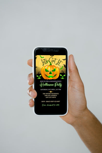 Hand holding a cell phone displaying a Yellow Smiley Neon Green Pumpkin Halloween Evite invitation, customizable via Canva for electronic sharing.