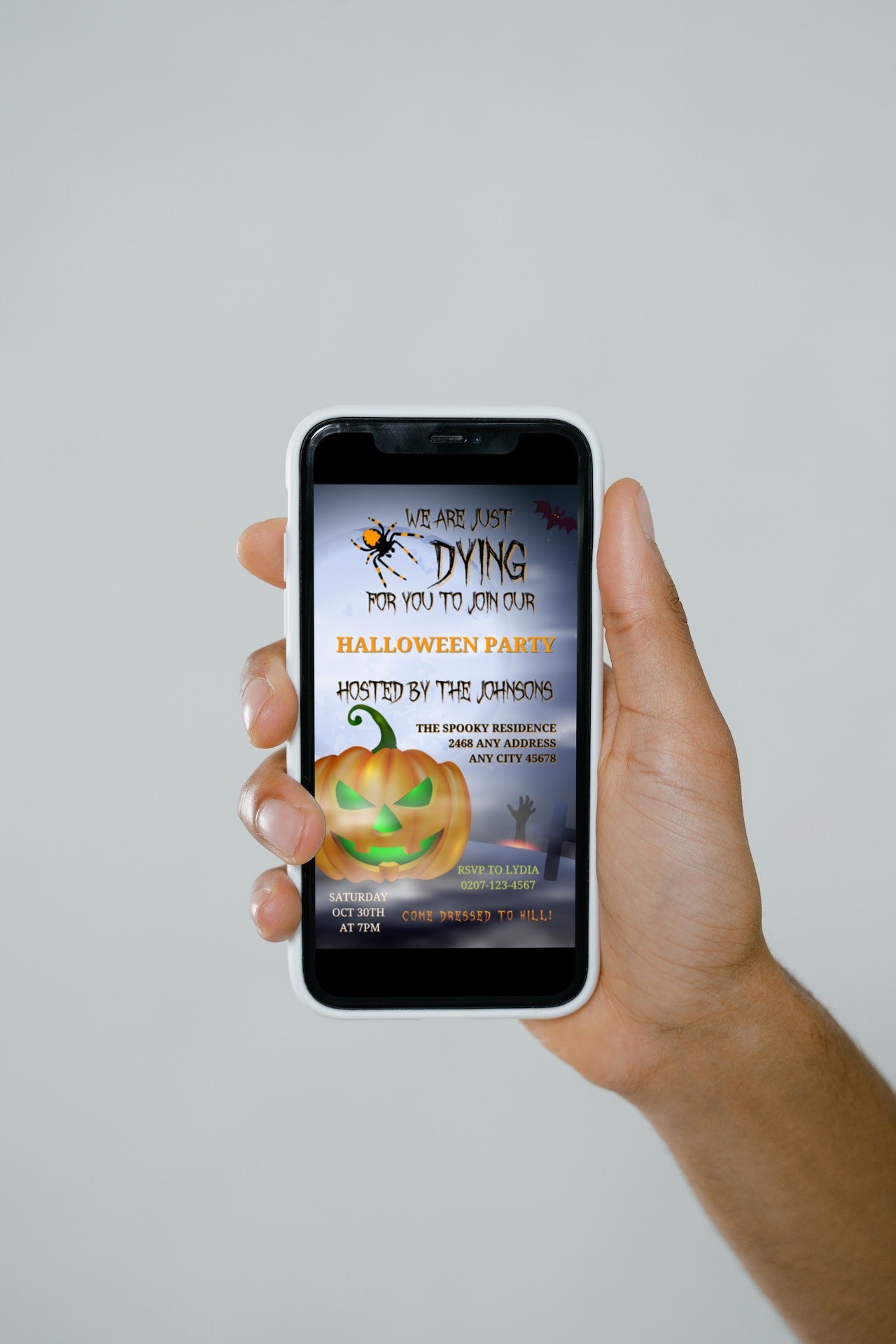 Hand holding a smartphone displaying the Flying Witch Neon Green Pumpkin | Halloween Evite customizable digital invitation template.