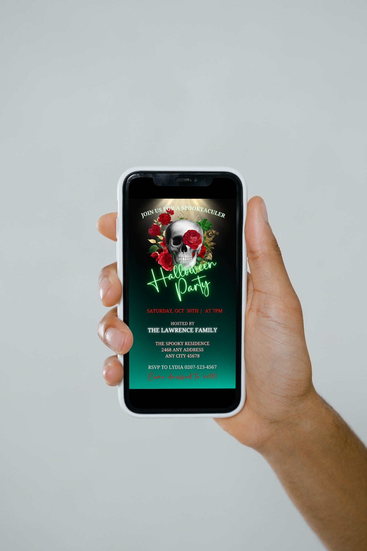 Hand holding a cell phone displaying a Red Rose Illuminated Skull Halloween Evite, customizable via Canva for digital invitations.