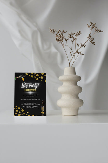 White vase with dried flowers beside a Black Leopard Gold Customisable Party Evite card on a table.