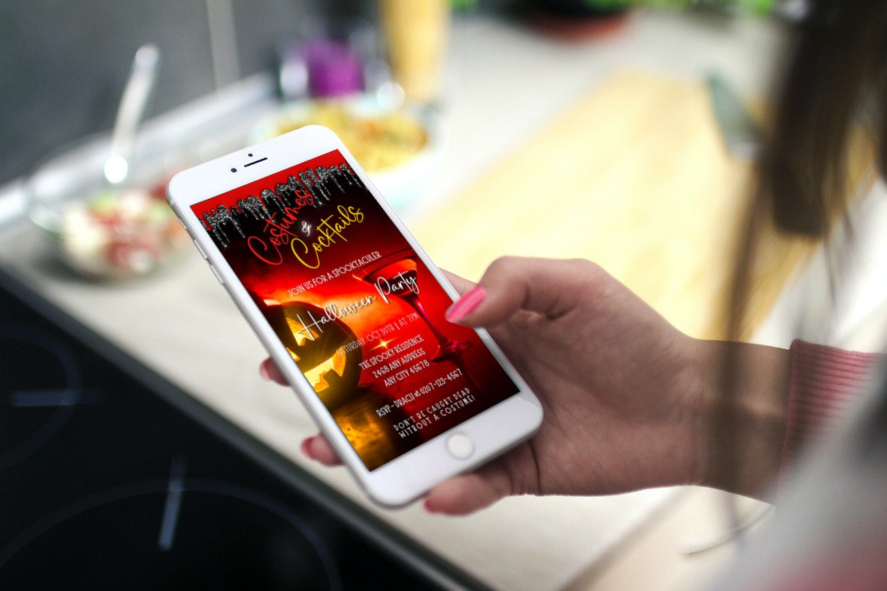 Hand holding a phone displaying a customizable Red Hot Pumpkin Costumes & Cocktails | Halloween Evite invitation template from URCordiallyInvited.