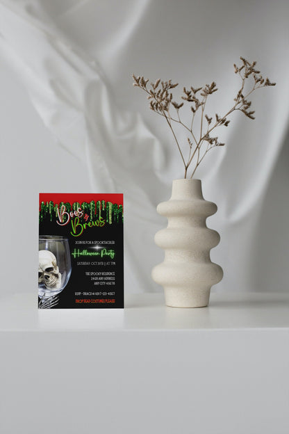 White vase with dried flowers beside Boos & Brews Glass Skull Halloween evite card, emphasizing digital invitation customization via Canva.