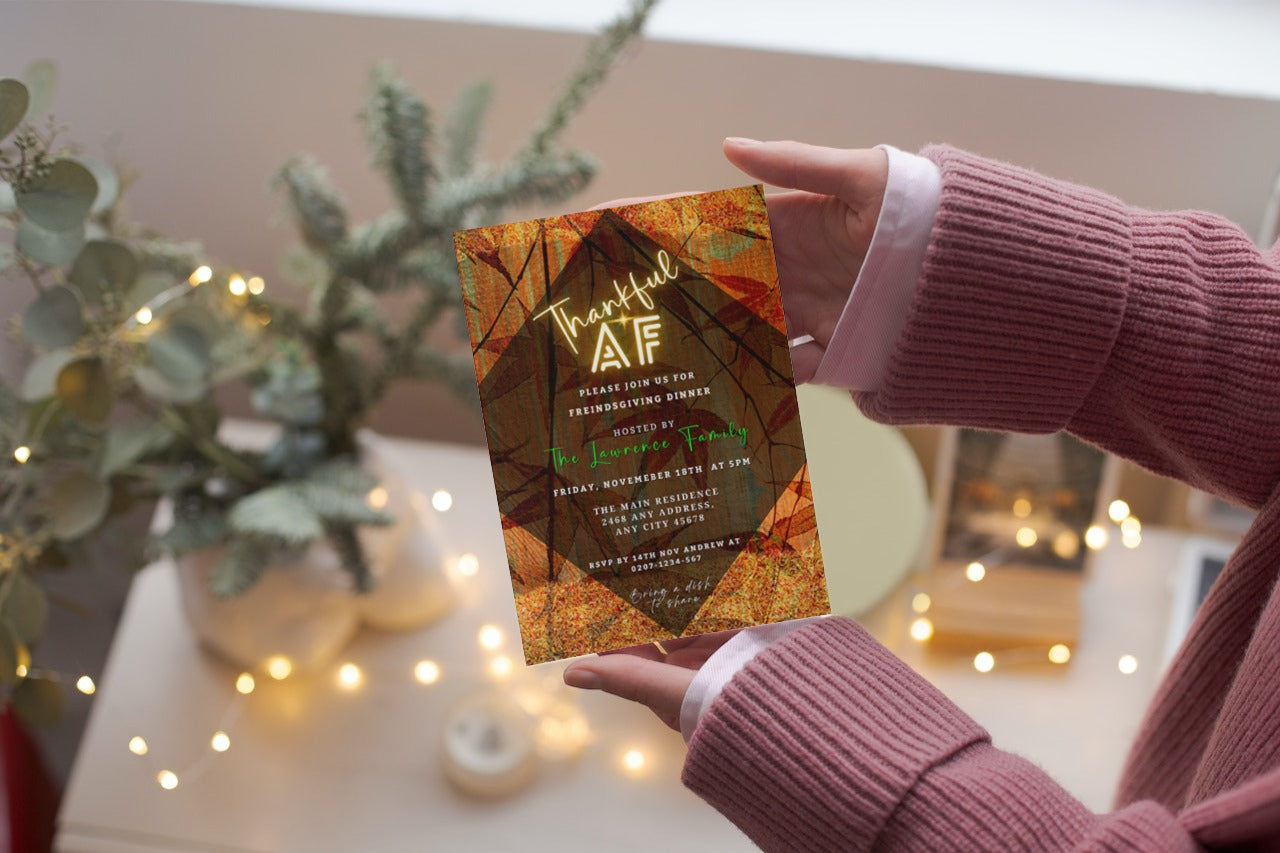 Person holding a Thankful AF Orange Gold Pumpkin Thanksgiving Dinner Evite card, showcasing customizable, eco-friendly digital invitation templates available for personalizing via Canva.