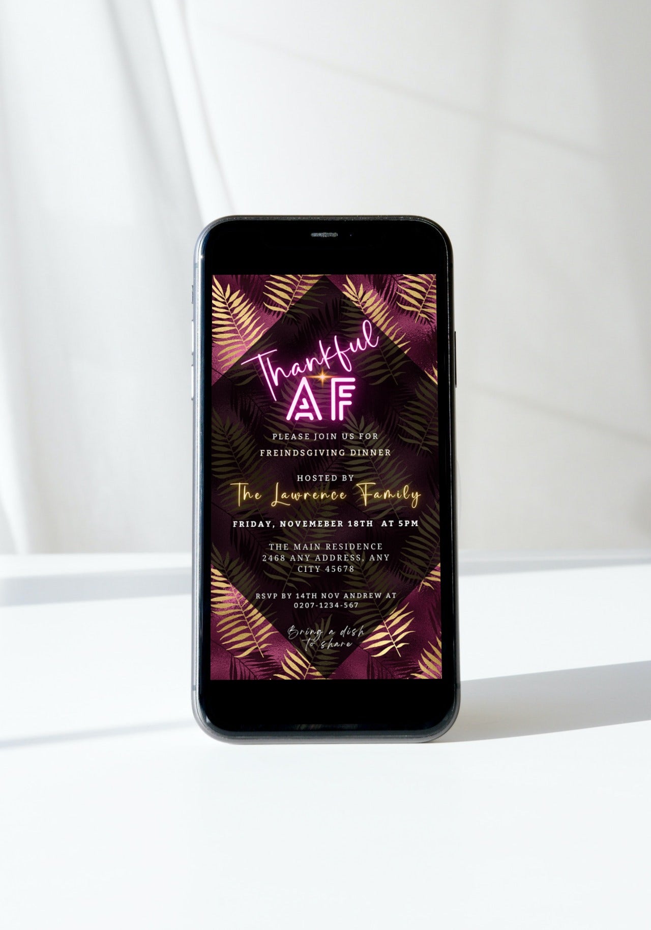Smartphone displaying a customizable Thanksgiving Dinner invitation with Thankful AF text on a purple and gold leaves background by URCordiallyInvited.
