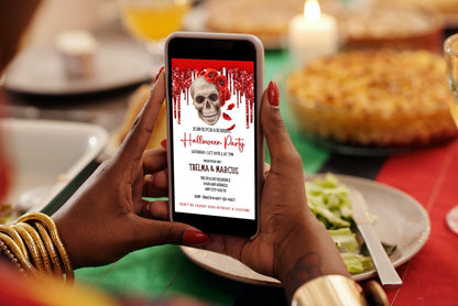 Person holding a phone displaying the Dripping Red Fancy Rosey Skull Halloween Evite, a customizable digital invitation template from URCordiallyInvited.