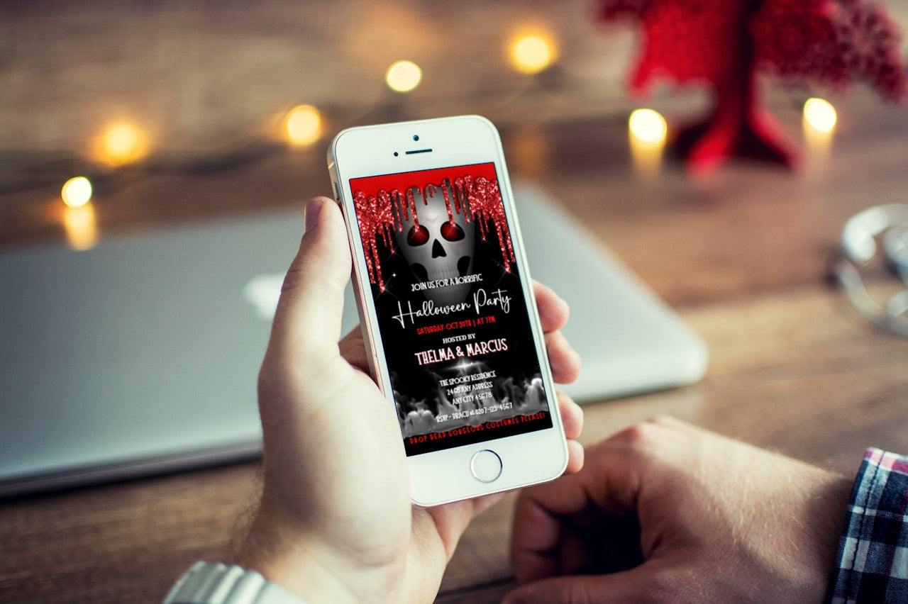 Person holding a smartphone displaying the Dripping Smoking Red Eyed Skull Halloween Party Video Invite template from URCordiallyInvited.