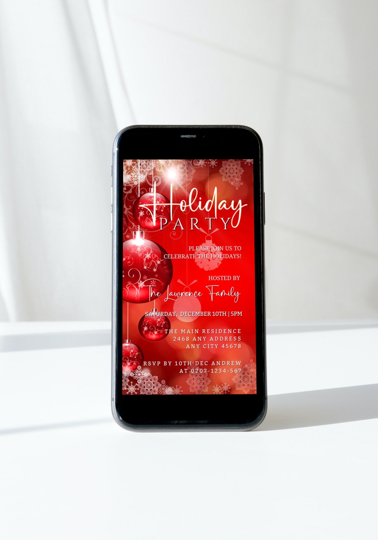 Cell phone displaying a customizable digital holiday party invitation with red and white ornaments, editable via Canva for smartphones.