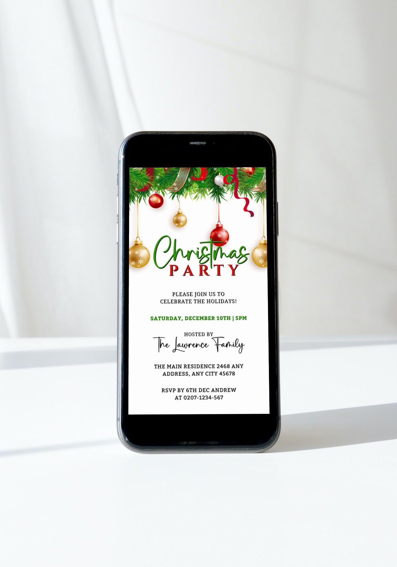 Smartphone displaying a customizable Christmas party invitation template with white, red, gold, and green ornaments from URCordiallyInvited.