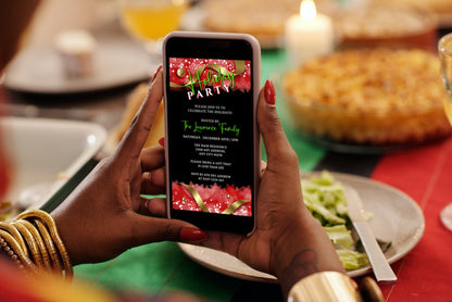 Person holding a smartphone displaying the Red Black Gold Ornament | Holiday Party Evite, a customizable digital invitation template available for editing via Canva.